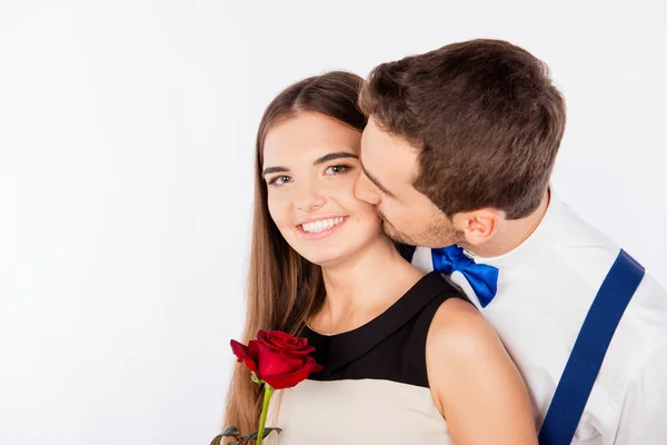 Lindo joven besando a su novia con una rosa — Foto de Stock