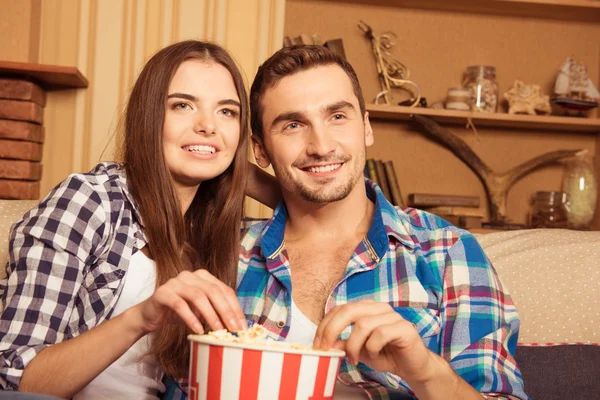 Uśmiechnięta para z popcornu, oglądając film w domu — Zdjęcie stockowe