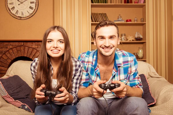 couple playing video games on the couch. concept about home ente