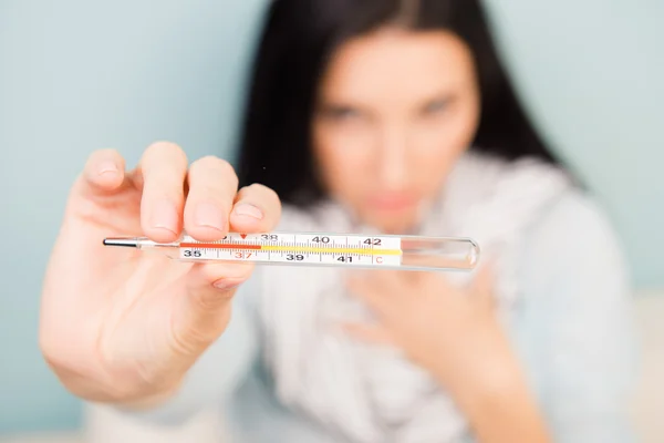 Mujer enferma mostrando alta temperatura en el termómetro — Foto de Stock