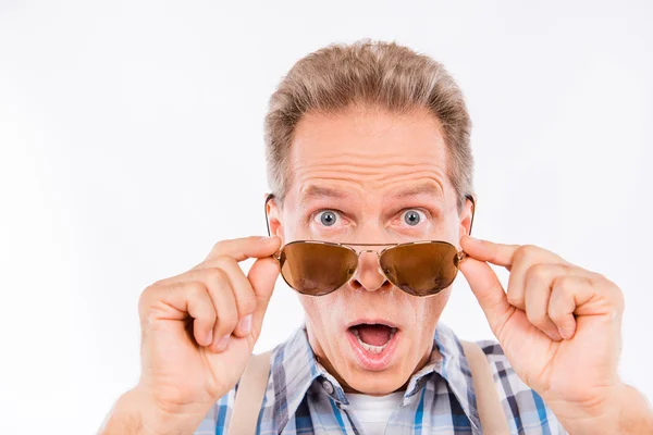 Surpreendido engraçado homem idoso em suspensórios segurando óculos — Fotografia de Stock