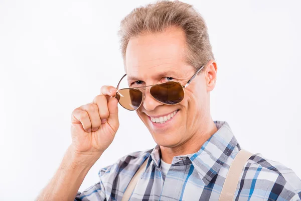 Happy aged man in suspenders holding glasses — Stock Photo, Image