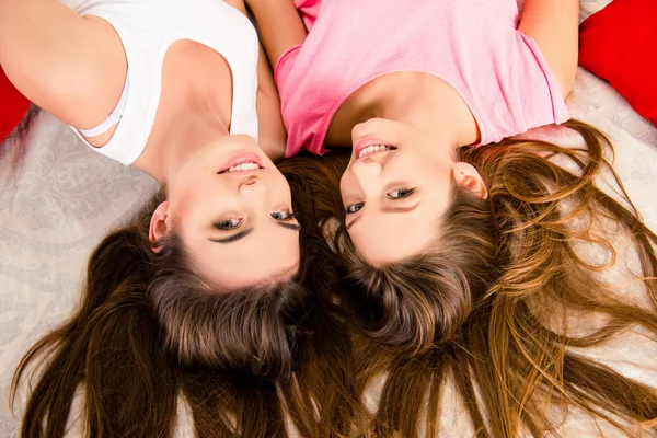 Сексуальные девушки в пижаме лежат на кровати с длинными волосами — стоковое фото