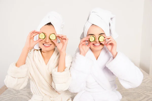 Funny cheerful young women with cucumbers on eyes and towel on t — Stock Photo, Image