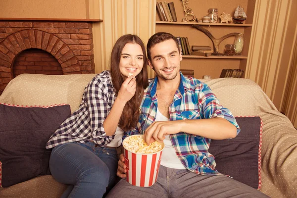 Jonge mooie paar thuis kijken naar een film en eten popco — Stockfoto