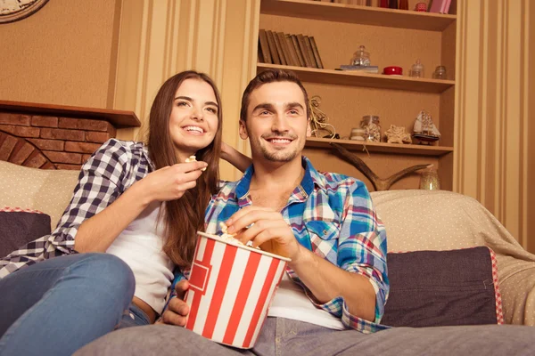 Νεαρό ζευγάρι στην αγάπη με ποπ κορν στον καναπέ βλέποντας μια ταινία — Φωτογραφία Αρχείου