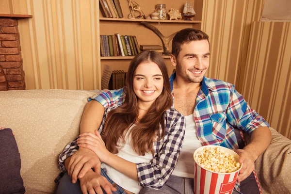 Jong paar in liefde tv kijken op een bank met popcorn — Stockfoto