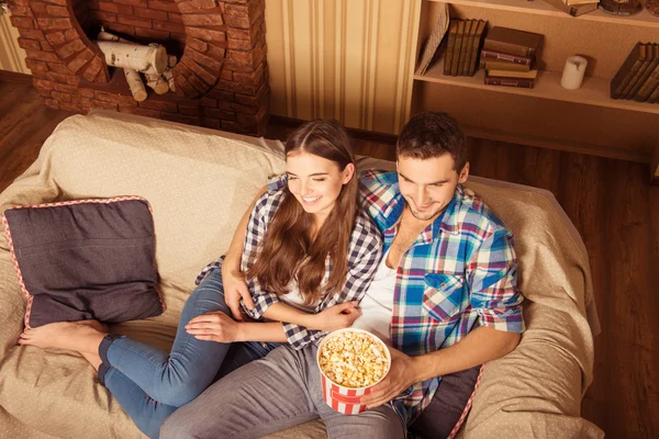 Aantrekkelijke paar tv kijken op de Bank thuis in levende roo — Stockfoto