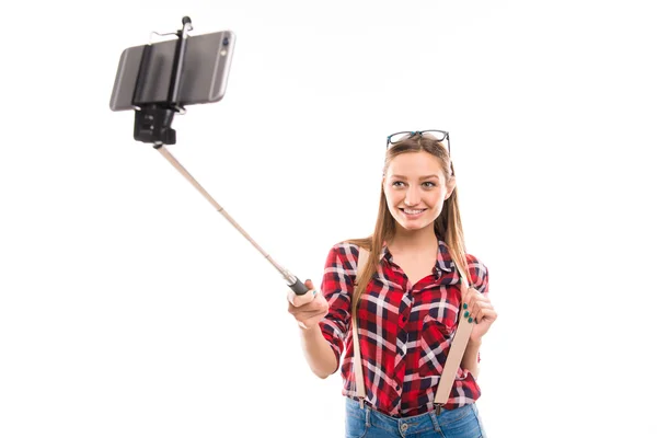 Long-haired girl with selfie stick taking photo — Stock Photo, Image