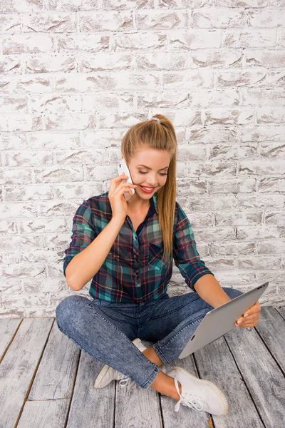 Menina bonita falando por telefone e trabalhando em tablet PC — Fotografia de Stock