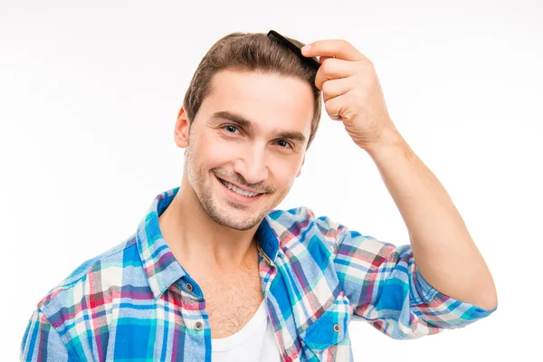 Un joven guapo posando con un peine sobre un fondo blanco —  Fotos de Stock