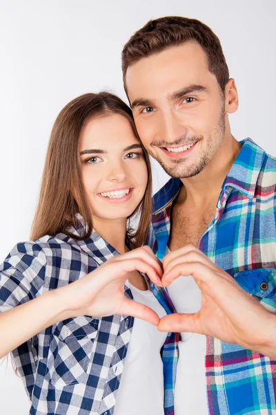 Glada par i kärlek omfamna varandra gestikulerande ett hjärta — Stockfoto