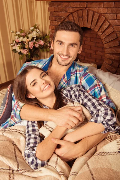 Vackra unga lyckliga paret kärlek ler på soffa — Stockfoto