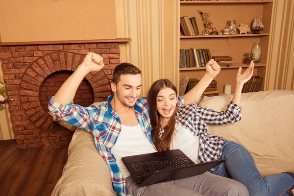 Alegre pareja en el amor con el ordenador portátil ganar y sentarse en el s — Foto de Stock