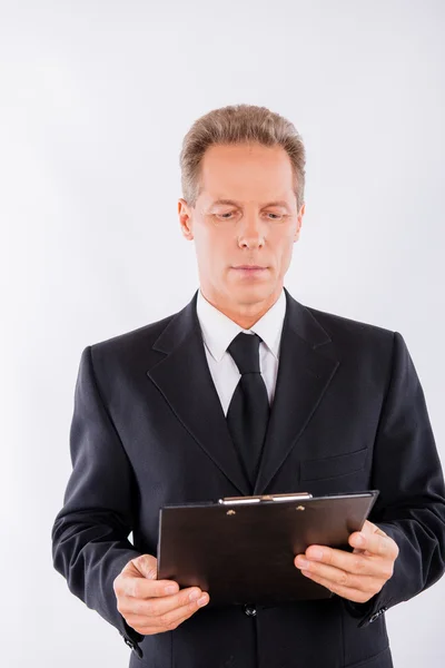 A portrait of focused man, who is working with clipboard Stock Image