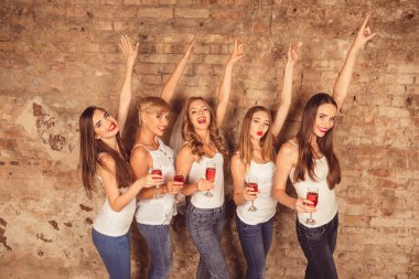 Cute girls celebrating hen-party with raised hands and stemware clipart