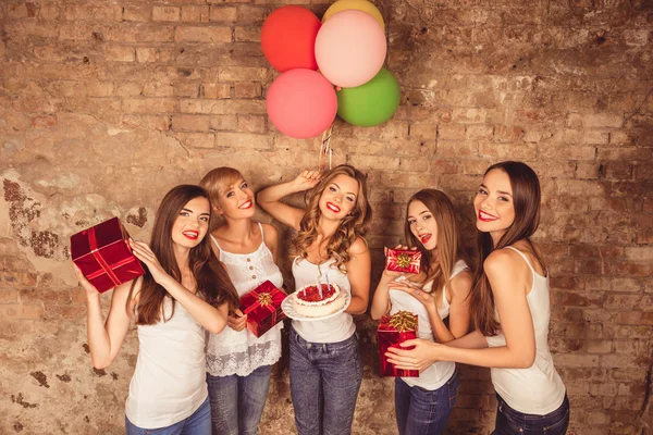 Усміхнені дівчата влаштовують вечірку з подарунками, тортами та повітряними кульками — стокове фото