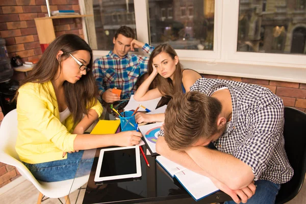 Grupo de estudiantes cansados trabajando duro juntos — Foto de Stock