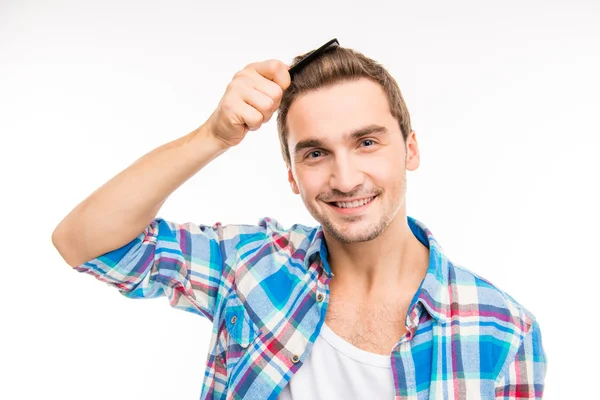 Handsome cheerful young man combing his hair — Stock Photo, Image