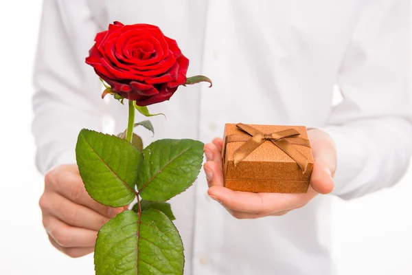 Foto de primer plano de un hombre guapo con una rosa roja y presente — Foto de Stock