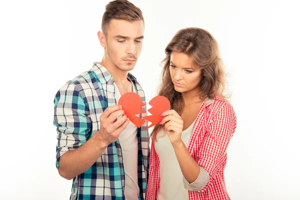 Jovem casal desconectado rasgando papel coração — Fotografia de Stock