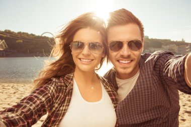 Two lovers making a selfie photo near the river, close-up photo clipart