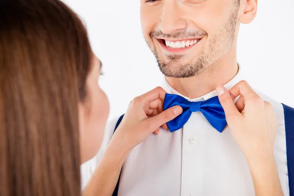 Closeup photo of a girl binding a blue bow to her boyfriend — Stock Photo, Image