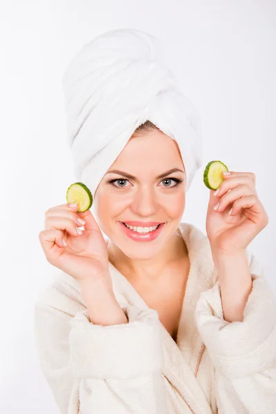 Uma menina bonita com fatias de pepino para o rosto — Fotografia de Stock