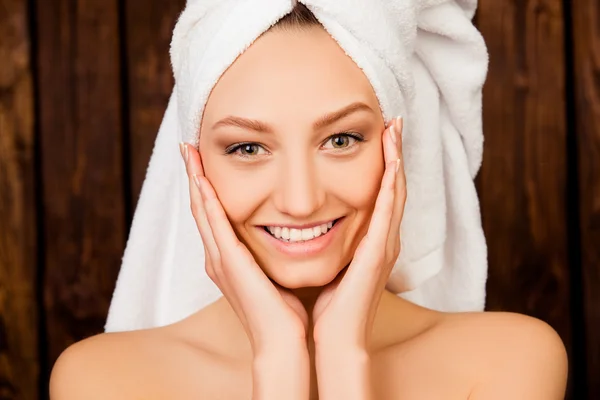 Attractive girl with towel on her head in spa salon touching che — Stock Photo, Image