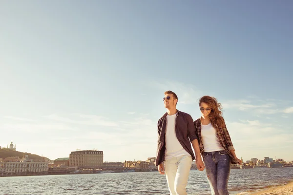 Junges Paar spaziert am Strand und hält Händchen — Stockfoto