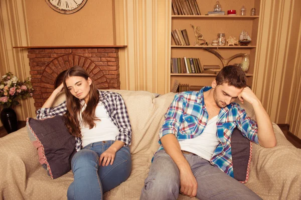 En casa una joven pareja sentada en el sofá en loggerheads — Foto de Stock