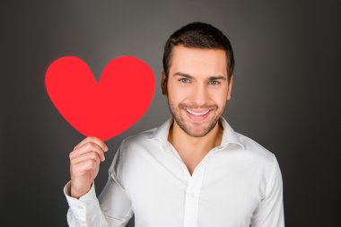 Close up photo of handsome man with paper heart in hand clipart