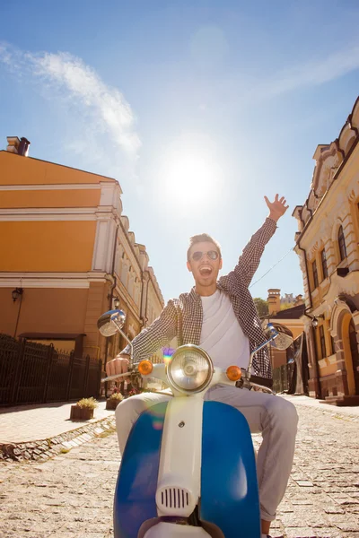 Bonito homem montando uma moto pegando ambas as mãos — Fotografia de Stock