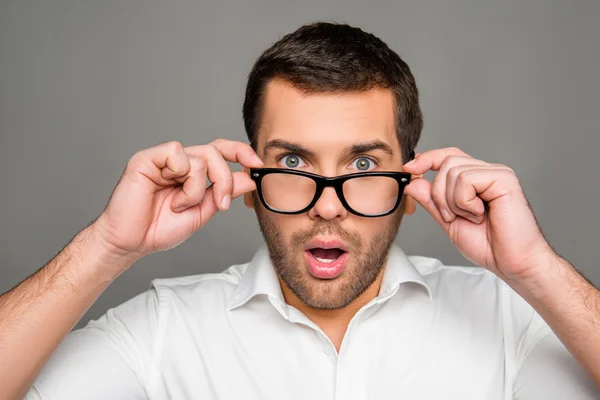 Surprised man touching glasses — Stock Photo, Image