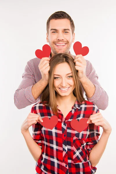 Pareja enamorada sosteniendo corazones de papel rojo — Foto de Stock