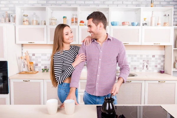 Glada par i kärlek att göra kaffe i köket — Stockfoto