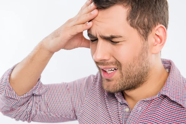 Guapo joven tocándose la cabeza con una mano sintiendo stron — Foto de Stock