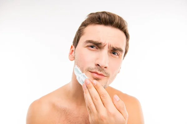 A young handsome man shaves in front of camera — Stock Photo, Image