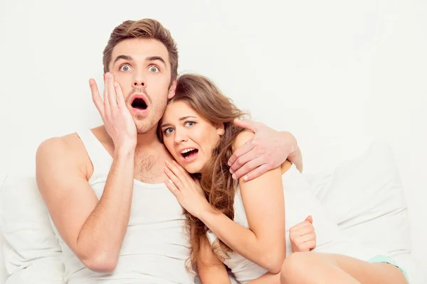 Scared young beautiful couple at home watching a movie — Stock Photo, Image