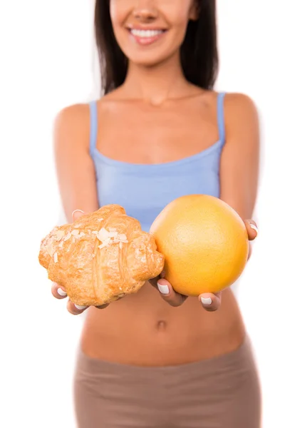 Linda chica elige entre un alimento saludable y comida dañina — Foto de Stock