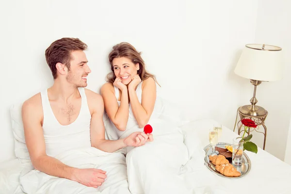 Jovem bonito homem fazendo uma proposta na cama — Fotografia de Stock