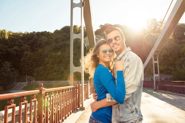 Pareja positiva enamorada en el puente abrazándose juntos —  Fotos de Stock