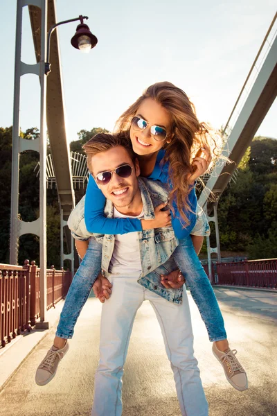 Pareja positiva enamorada en el puente con gafas — Foto de Stock