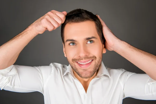 Stilig glad ung man kamma hans hår — Stockfoto