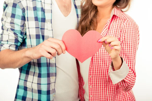 Preciosa pareja enamorada sosteniendo el corazón de papel — Foto de Stock