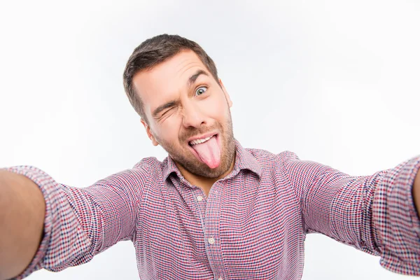 Hombre atractivo haciendo selfie cómico con lengua — Foto de Stock