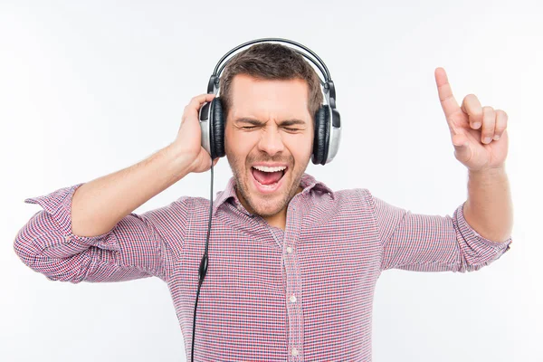 Hombre alegre en auriculares escuchando música y haciendo gestos con fi — Foto de Stock