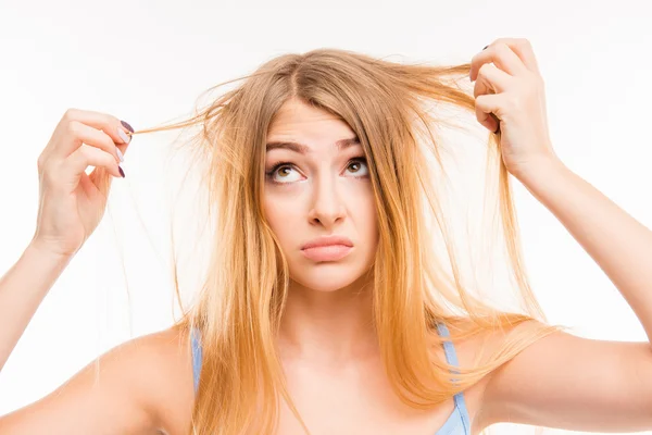 Menina triste olhando para seu cabelo danificado — Fotografia de Stock