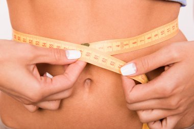 Close up photo of girl's waist with a measuring tape clipart