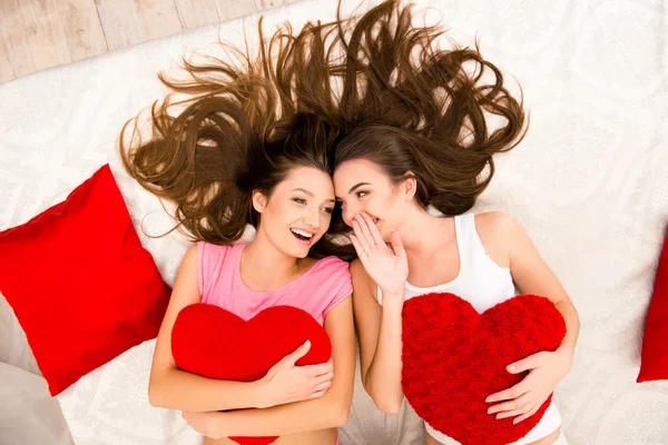 Cheerful beautiful girls in pajamas gossiping and lying on the b — Stock Photo, Image